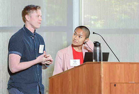 Two UC San Diego students present their research, standing at a podium, at the 2019 Undergraduate Research Conference