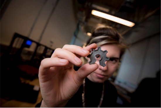 UC San Diego student peers through a plastic 3D printed part